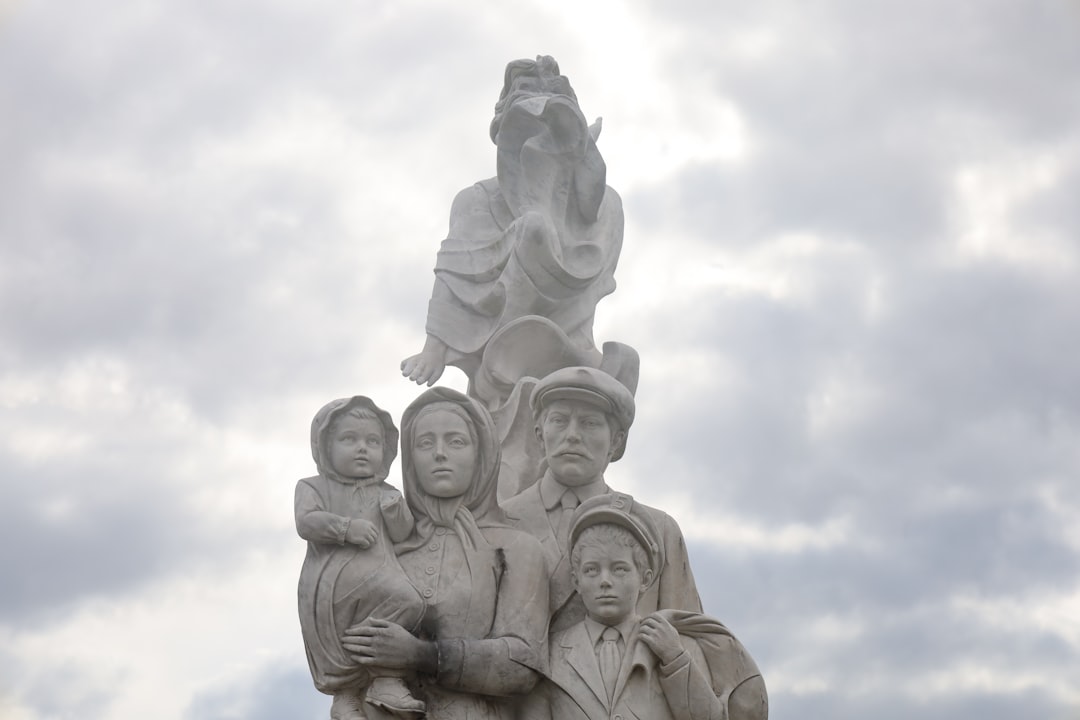 Statue depicts a family with cloudy skies.