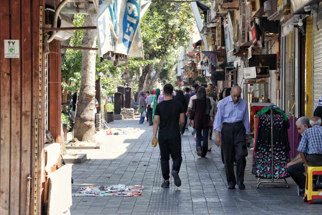 a group of people walking down a street next to shops
