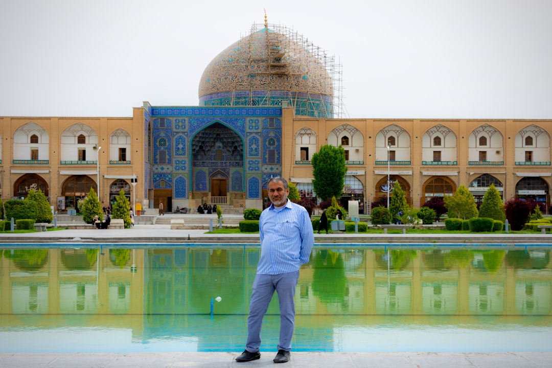 A man standing in front of a large building