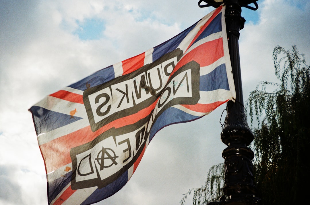 A flag flying in the wind on top of a lamp post