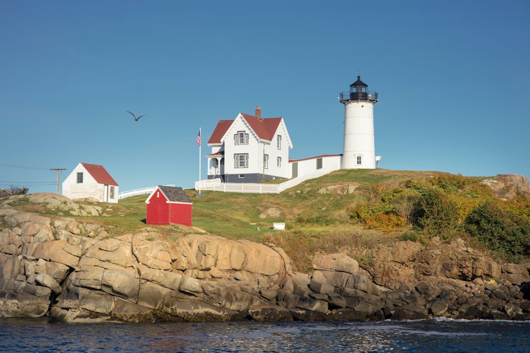 white concrete house near white lighthouse during daytime